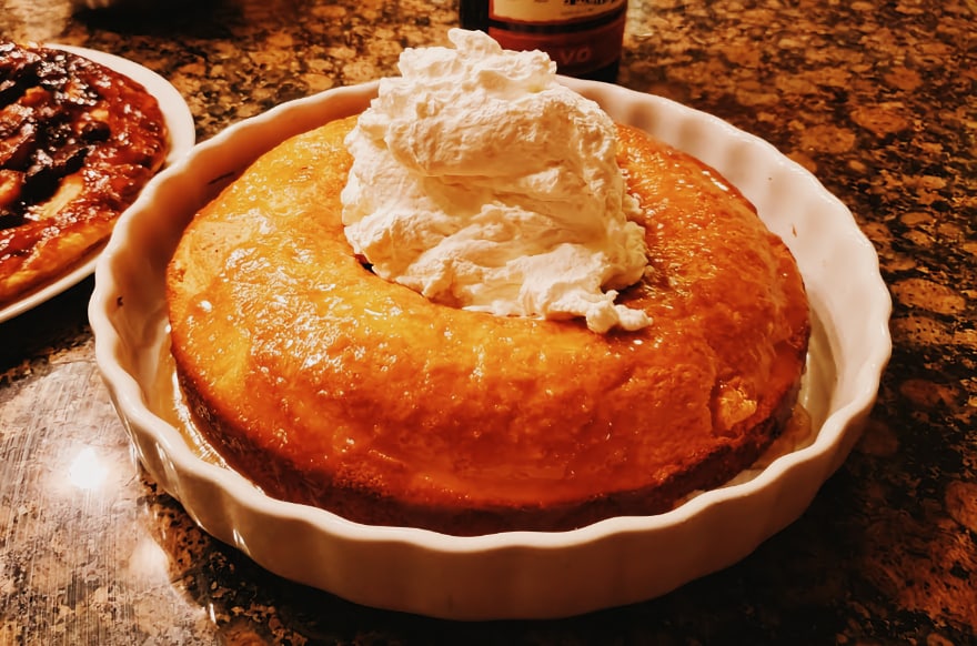 A rum baba with whipped cream, sitting on the counter